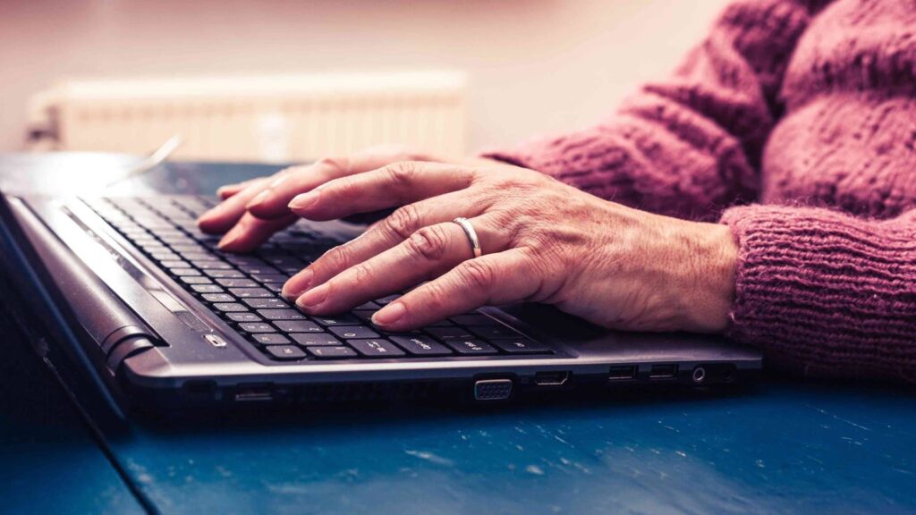 Older woman filling out a Social Security disability application on a laptop